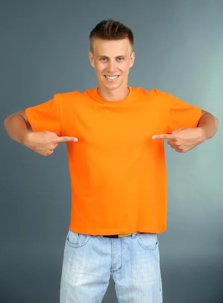 Camiseta sobre hombre joven, sobre fondo gris — Foto de Stock