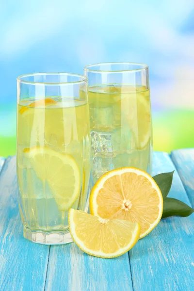 Heerlijke limonade op tafel op blauwe achtergrond — Stockfoto