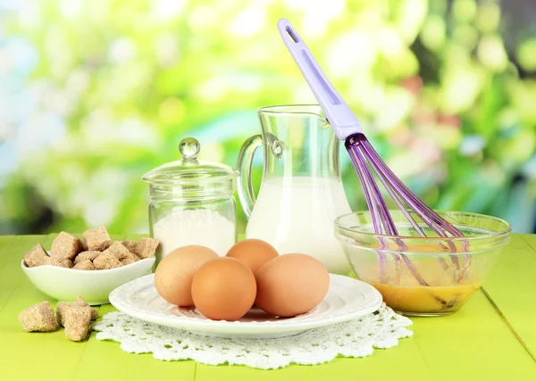 Ingredients for dough on wooden table on natural background — Stock Photo, Image