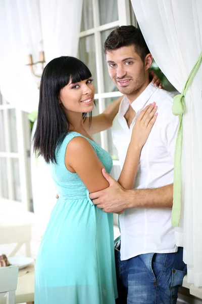 Beautiful young romantic couple near window — Stock Photo, Image