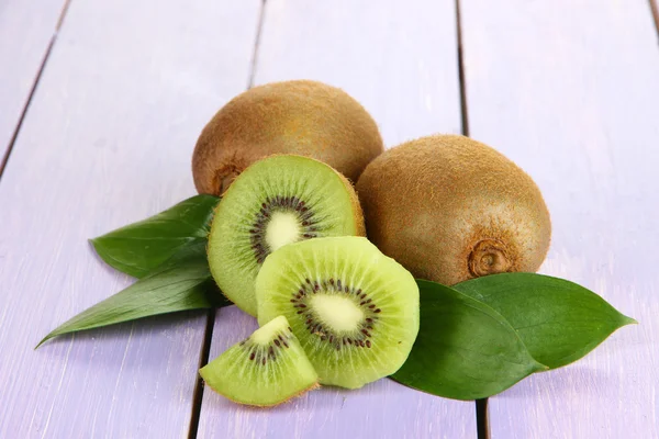 Reife Kiwi auf violettem Holztisch in Großaufnahme — Stockfoto