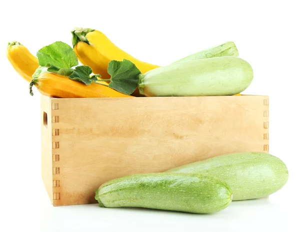 Raw yellow and green zucchini in wooden crate, isolated on white — Stock Photo, Image