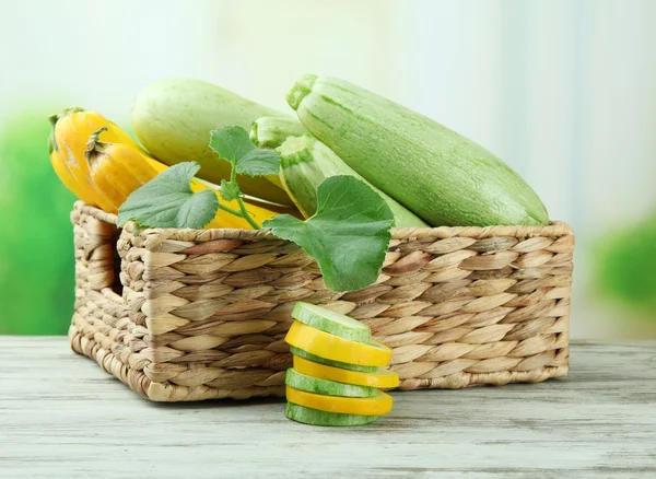 In Scheiben geschnittene und ganze rohe Zucchini in Weidenkiste, im Freien — Stockfoto