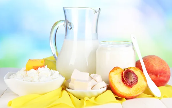 Productos lácteos frescos con melocotones sobre mesa de madera sobre fondo natural —  Fotos de Stock
