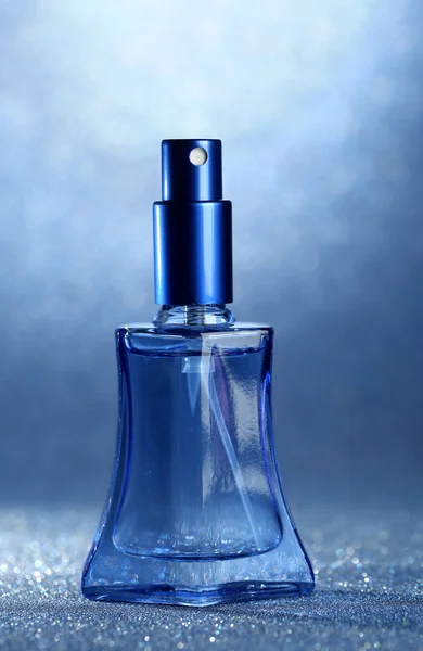 파란색 배경에 아름 다운 병에 여성 향수 — 스톡 사진