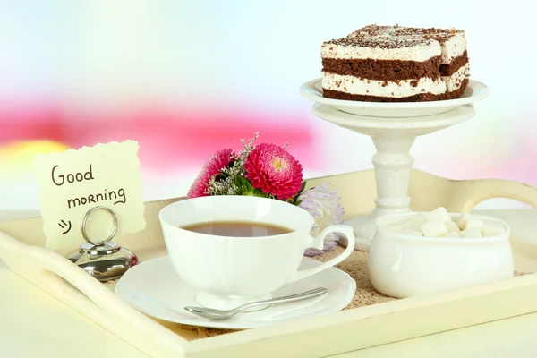 Cup of tea with cakes on wooden tray on table in room — Stock Photo, Image