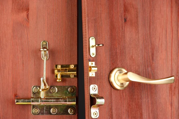 Metal bolts, latches and hooks in wooden open door close-up — Stock Photo, Image