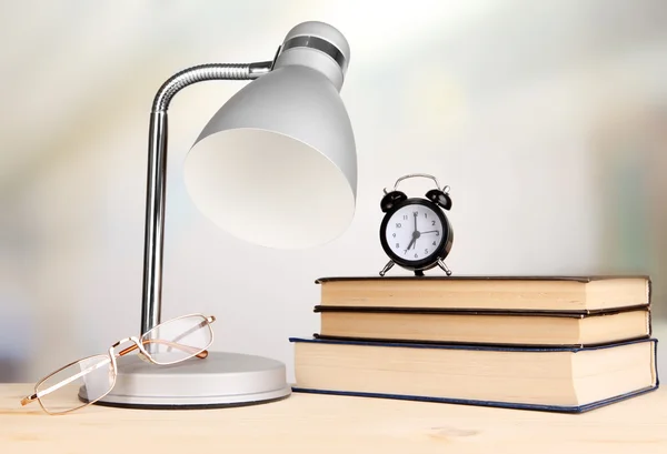 Bordslampa och böcker på skrivbord i rummet — Stockfoto