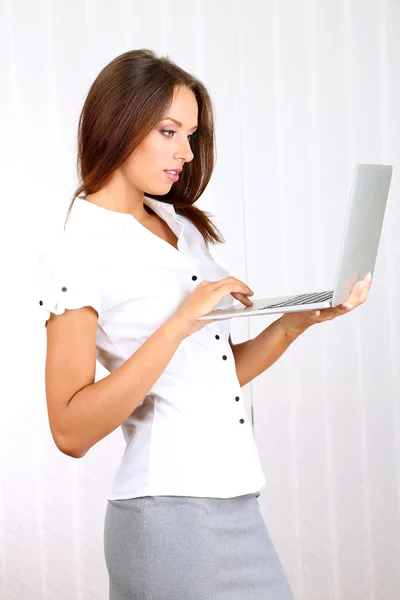 Giovane bella donna d'affari con computer portatile in ufficio — Foto Stock