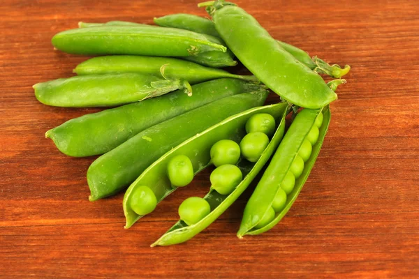 Zoete groene erwten op houten achtergrond — Stockfoto