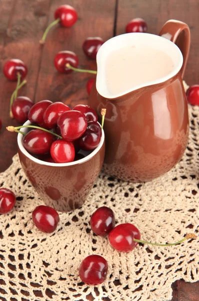 Bayas rojas maduras de cereza en taza sobre mesa de madera de cerca — Foto de Stock