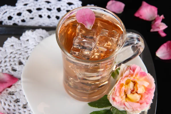 Copa de vidrio de té helado de rosa de té en bandeja metálica en servilleta sobre fondo negro — Foto de Stock