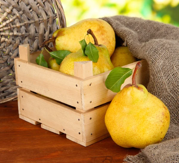 Juicy pears in wooden box on table on bright background — Stock Photo, Image