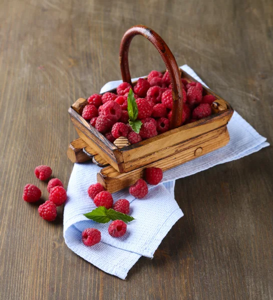 Ripe sweet raspberries in basket on wooden background — Stock Photo, Image