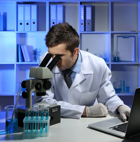 Laboratorium młody naukowiec patrząc mikroskopu w laboratorium — Zdjęcie stockowe