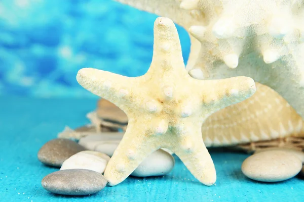 White starfishes on blue wooden table on sea background — Stock Photo, Image