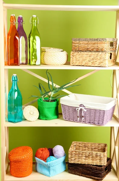 Beautiful white shelves with different home related objects, on color wall background — Stock Photo, Image