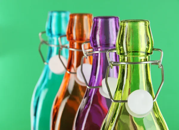 Colorful bottles on green background — Stock Photo, Image