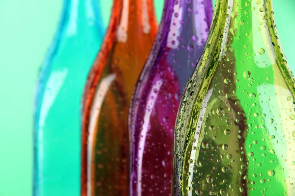 Colorful bottles on green background — Stock Photo, Image