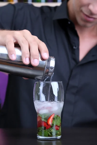 Portrait of handsome barman preparing cocktail, at bar — Stock Photo, Image