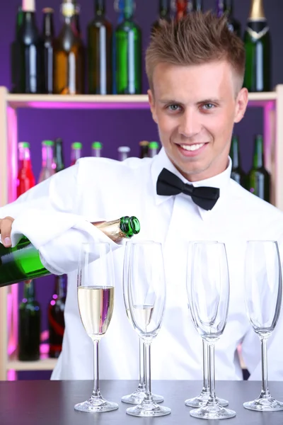 Barman está derramando champanhe em copos — Fotografia de Stock