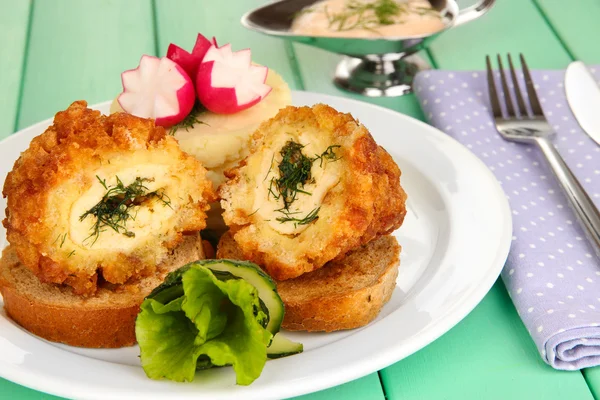 Chicken Kiev on croutons with mashed potatoes, on wooden table, on bright background — Stock Photo, Image