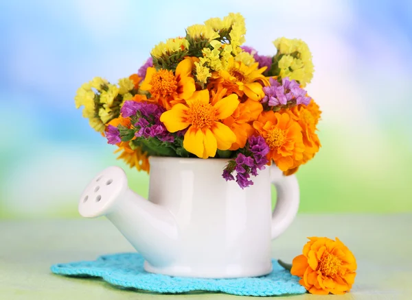 Boeket van Goudsbloem bloemen in gieter op houten tafel op natuurlijke achtergrond — Stockfoto