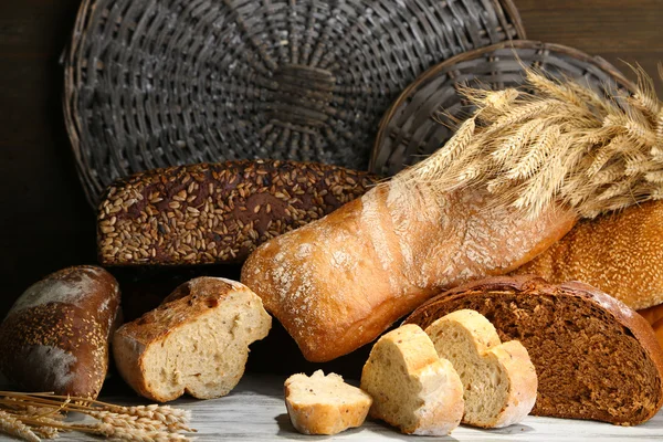 Muito pão na placa de madeira no fundo da bandeja de vime — Fotografia de Stock