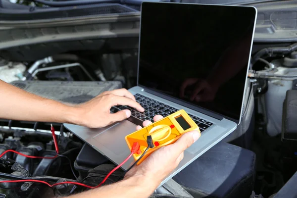 Mecánico profesional de automóviles que trabaja en el servicio de reparación de automóviles —  Fotos de Stock