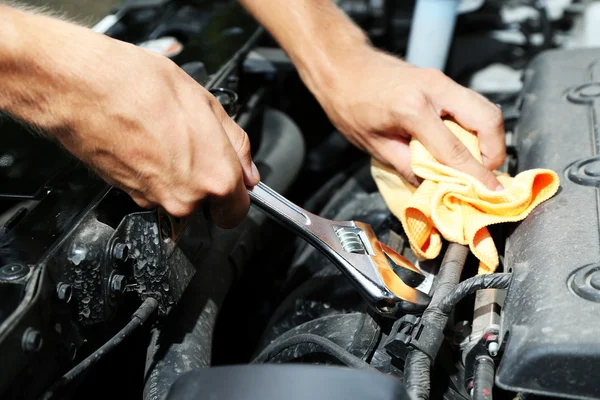 Hand mit Schraubenschlüssel. Automechaniker in der Autoreparatur Stockfoto