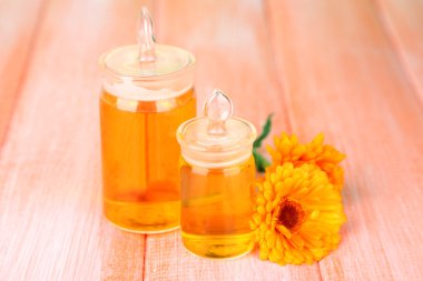 ilaç şişeleri ve ahşap zemin üzerine calendula çiçekler