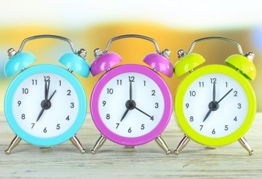 Tablo parlak arka plan üzerinde renkli çalar saatler