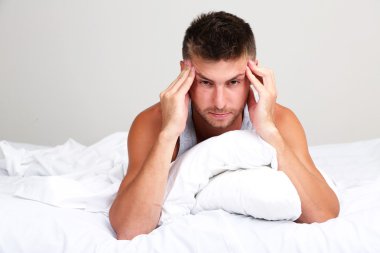 Yakışıklı genç adam yatakta.