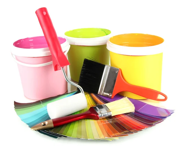 Paint pots, paintbrushes and coloured swatches close up — Stock Photo, Image