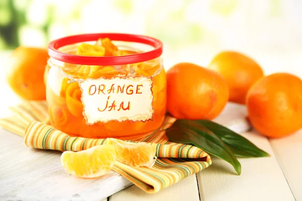 Engarrafamento de laranja com raspas e tangerinas, sobre mesa de madeira branca — Fotografia de Stock