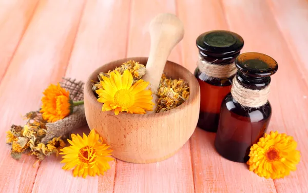 Medicin flaskor och ringblomma blommor på trä bakgrund — Stockfoto