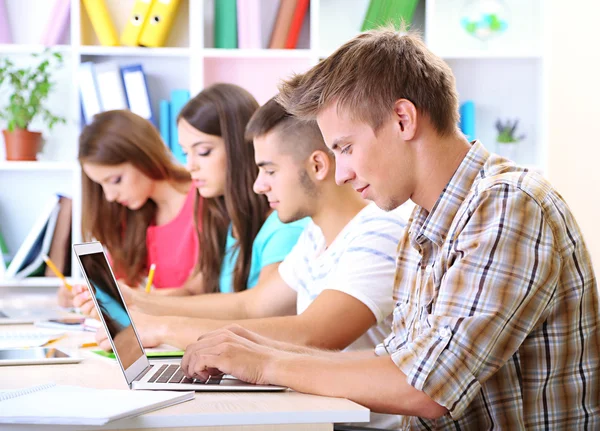 Groep van jonge studenten zitten in de bibliotheek — Stockfoto