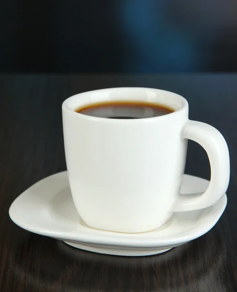 Filiżankę kawy na drewnianym stole na jasnym tle — Zdjęcie stockowe