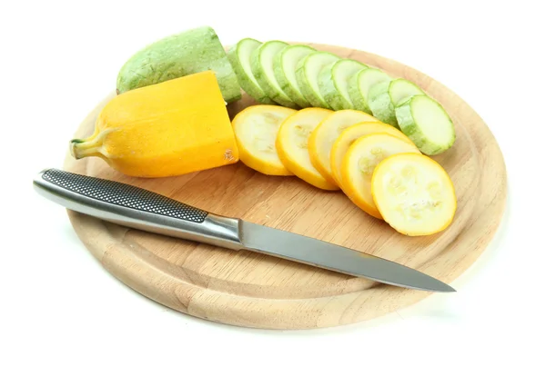 Sliced and whole raw zucchini on wooden cutting board, isolated on white — Stock Photo, Image