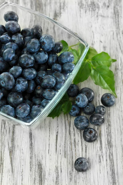 Bosbessen in glazen schaal op houten tafel — Stockfoto