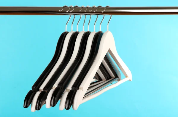 Black and white clothes hangers on color background — Stock Photo, Image