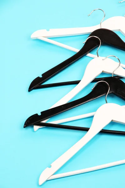 Black and white clothes hangers on color background — Stock Photo, Image