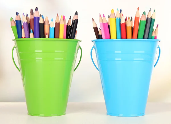 Renk renk arka plan üzerinde renkli kalemler ile kova — Stok fotoğraf