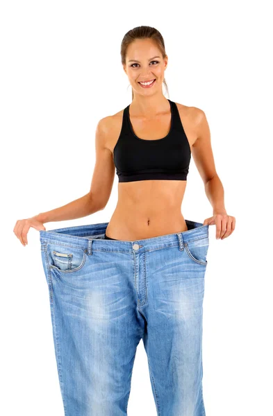Slim meisje in grote jeans geïsoleerd op wit — Stockfoto