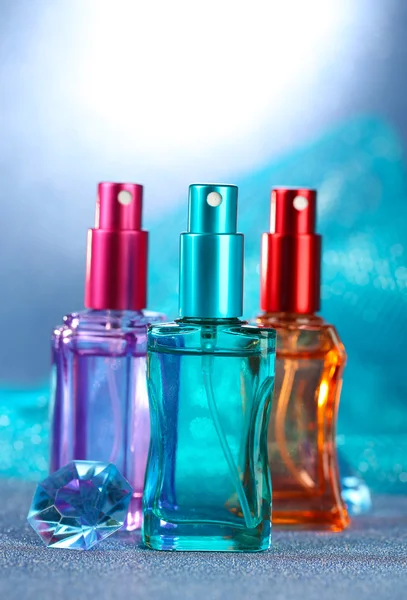Donne profumo in belle bottiglie su sfondo blu — Foto Stock