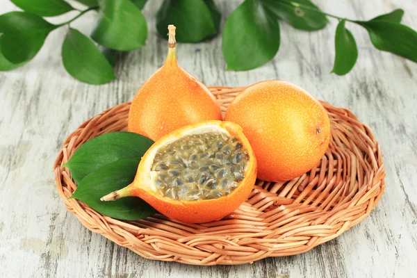 Passion fruits on wicker mat on table close-up — Stock Photo, Image