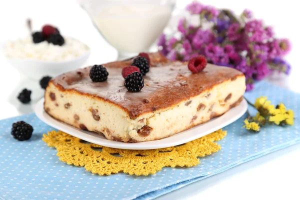 Cheese casserole with raisins on plate on napkin isolated on white — Stock Photo, Image