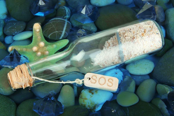 Bottle with letter on sea bottom with shells and stones — Stock Photo, Image