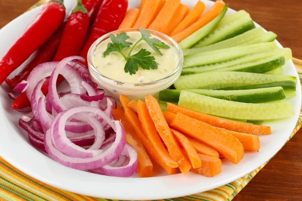 Bâtonnets de légumes crus assortis dans une assiette sur une table en bois fermer — Photo