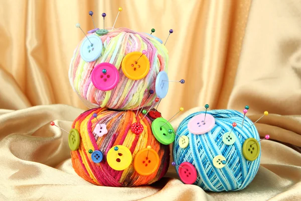 Botones coloridos y bolas de lana multicolor, sobre fondo de tela de color —  Fotos de Stock